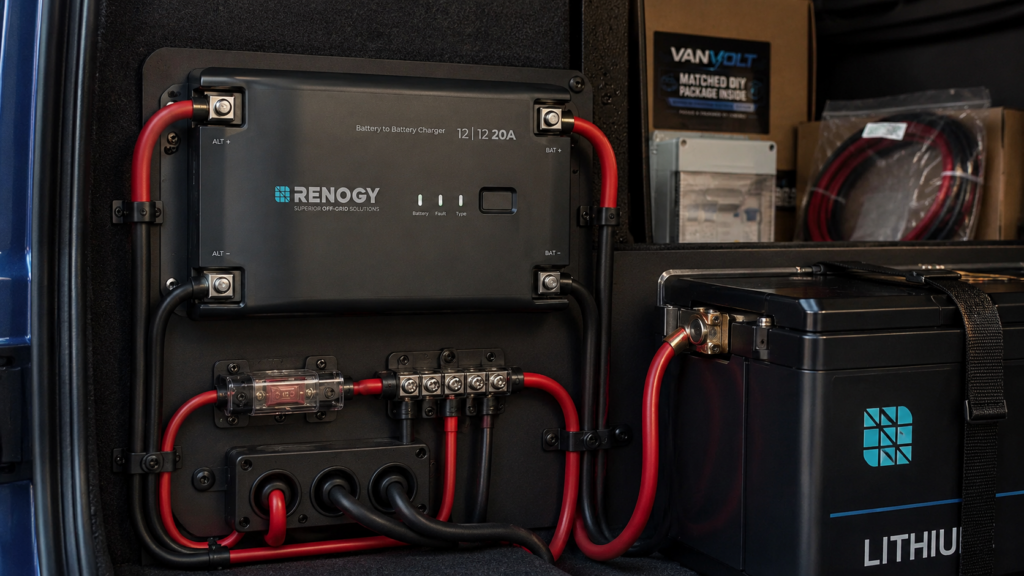 Campervan DC-DC charger installed beside a lithium leisure battery with red and black cabling, fuse protection and VanVolt package boxes.